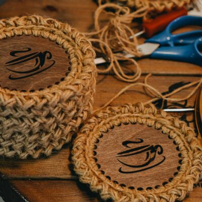 Close-up of handmade crochet wood coasters on a wooden table, showcasing arts and crafts.